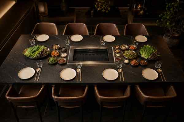 A Korean barbecue table arranged with exactly eight place settings.
