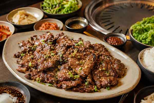 Finished Garlic-Sesame Galbisal presented in a warm Korean dining setting.
