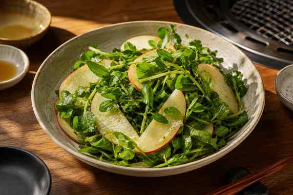 Finished Watercress-Apple Yuja Salad presented in a warm Korean dining setting.