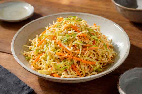 Finished Gochugaru-Yuja Cabbage Slaw presented in a warm Korean dining setting.
