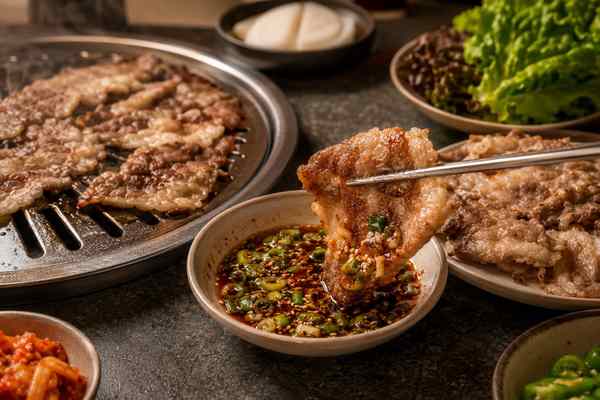 Finished Chadolbaegi with Scallion-Soy Dipping Sauce presented in a warm Korean dining setting.