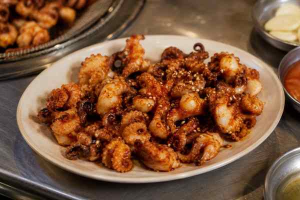 Finished Jjukkumi Gui Grilled Baby Octopus presented in a warm Korean dining setting.