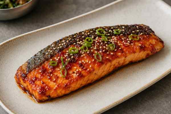 Finished Gochujang-Glazed Grilled Salmon presented in a warm Korean dining setting.