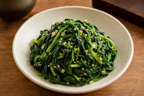 Finished Sigeumchi Namul Seasoned Spinach presented in a warm Korean dining setting.
