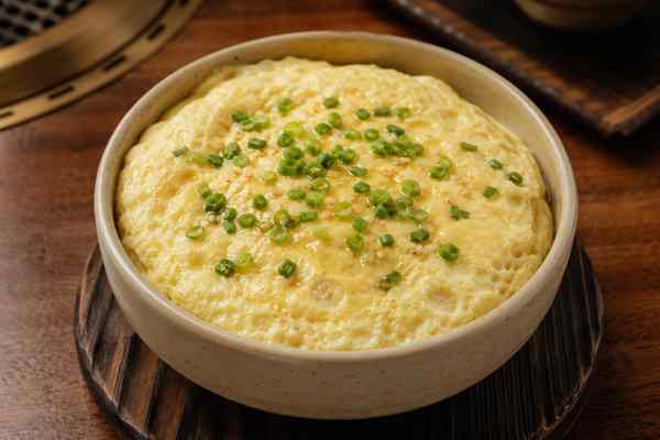 Finished Gyeran Jjim Steamed Eggs presented in a warm Korean dining setting.