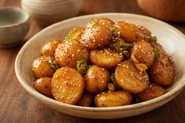 Finished Gamja Jorim Soy-Braised Potatoes presented in a warm Korean dining setting.