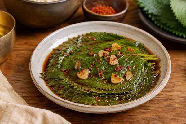 Finished Kkaennip Jangajji Pickled Perilla Leaves presented in a warm Korean dining setting.