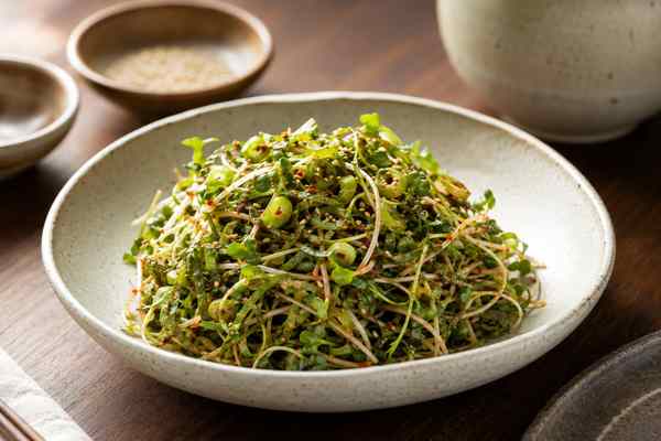 Finished Radish Sprout and Perilla Salad presented in a warm Korean dining setting.