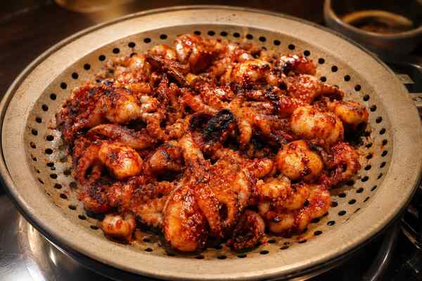 Finished Spicy Grilled Nakji Octopus presented in a warm Korean dining setting.