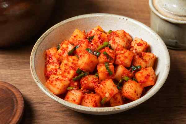 Finished Kkakdugi Radish Kimchi presented in a warm Korean dining setting.