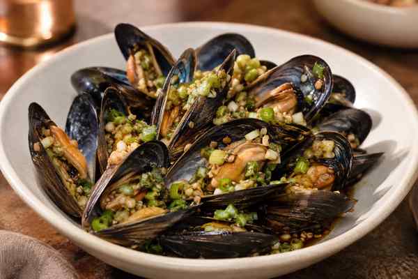 Finished Garlic-Scallion Grilled Mussels presented in a warm Korean dining setting.