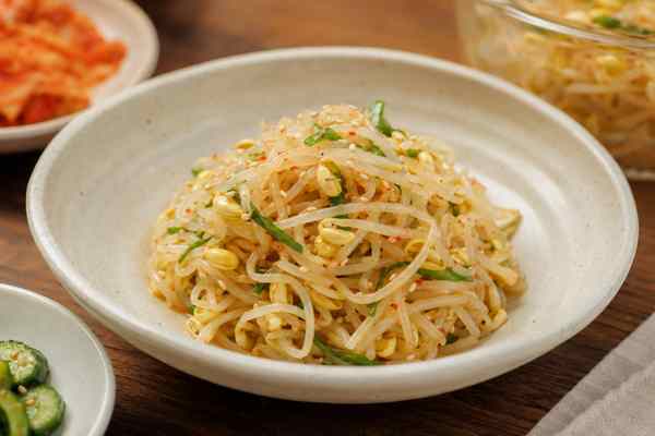 Finished Kongnamul Muchim Seasoned Soybean Sprouts presented in a warm Korean dining setting.
