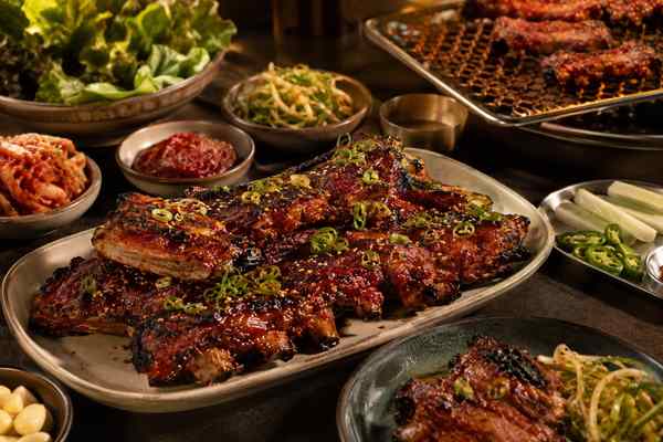 Finished Korean-Style Gochujang Grilled Pork Ribs presented in a warm Korean dining setting.