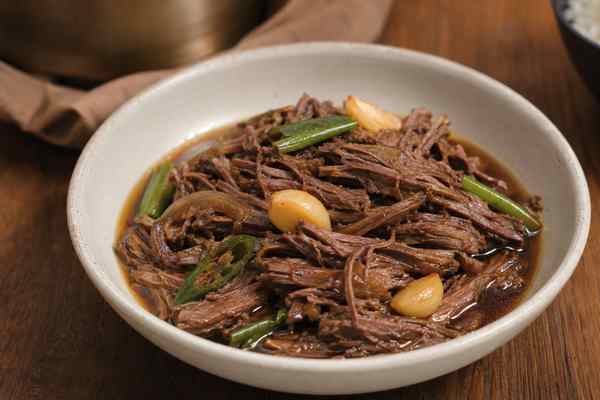 Finished Jangjorim Soy-Braised Beef presented in a warm Korean dining setting.