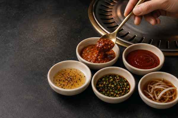 Ssamjang and several Korean barbecue dipping sauces in small cream ceramic bowls.